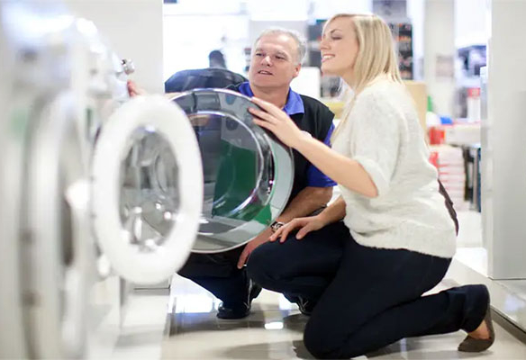 Man and a woman inspecting a brand new washing machine